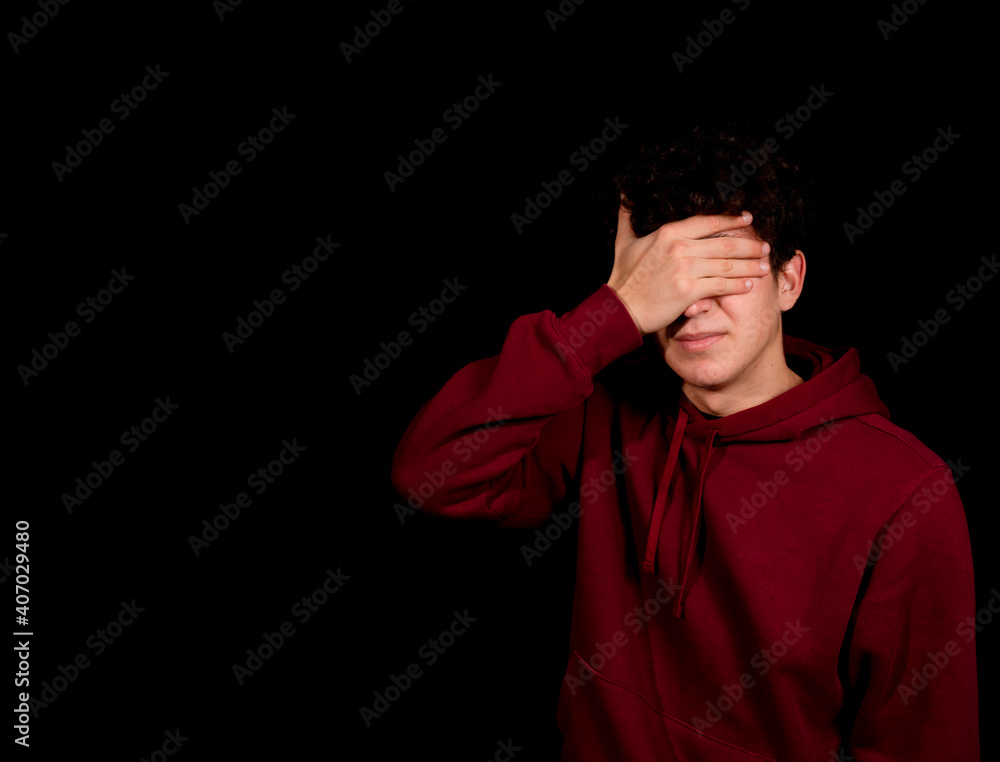 Attractive young man with curly hair posing on black studio background Attractive young man with curly hair posing on black studio background