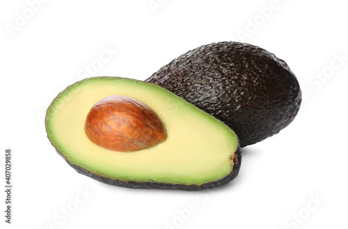 Cut and whole ripe avocadoes on white background