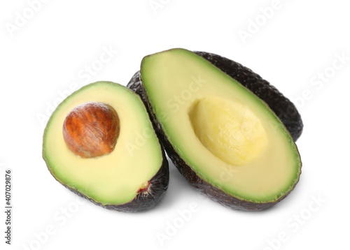 Cut and whole ripe avocadoes on white background