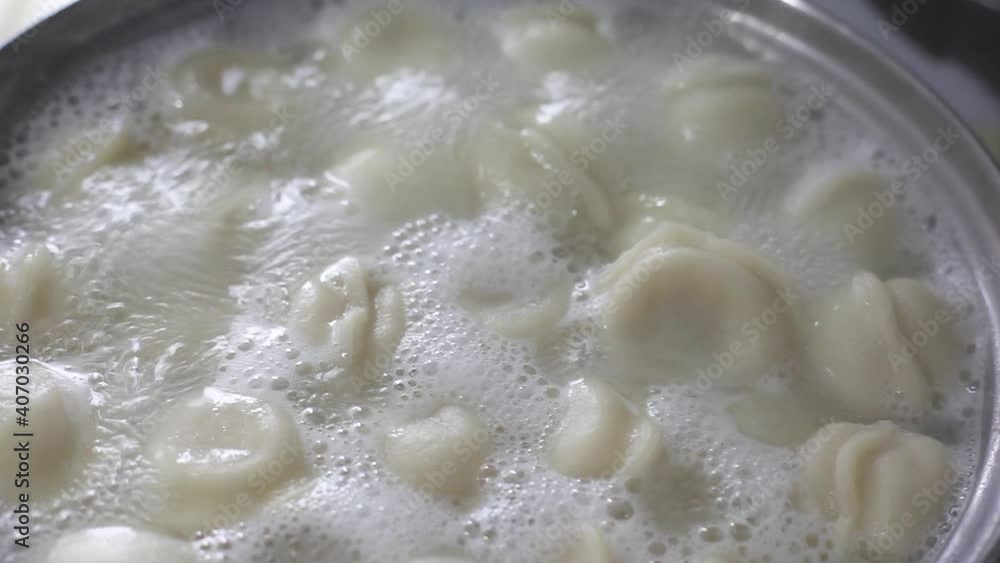 Cooking dumplings in a saucepan. Dumplings are cooked in boiling water, there is steam. Full HD video quality Cooking dumplings in a saucepan. Dumplings are cooked in boiling water, there is steam. Full HD video quality
