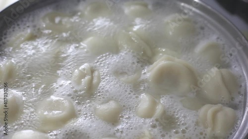 Cooking dumplings in a saucepan. Dumplings are cooked in boiling water, there is steam. Full HD video quality