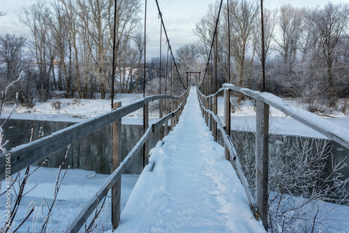 an invitation to walk a suspension bridge over a freezing river on a frosty winter day. photo taken in the Middle Urals, Russia. The beauty of winter nature, the ability to see beauty in detail