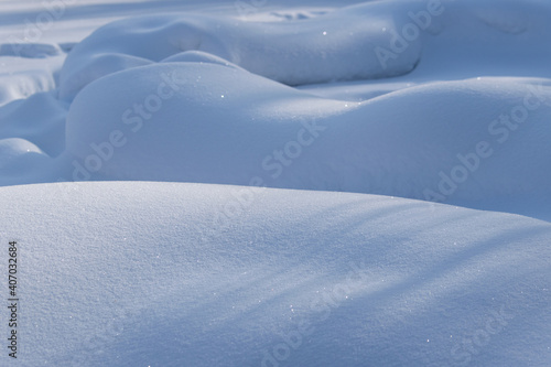 Perfectly smooth snow in a snowdrift, sparkling in the sun. Textured grainy snow background. Natural photowall-paper. Photo taken in the Urals, Russia. the beauty of nature in the smallest detail.