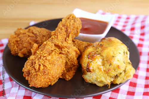 Plate of Golden Brown Crispy Fried Chicken Drumsticks with Garlic and Herb Biscuit