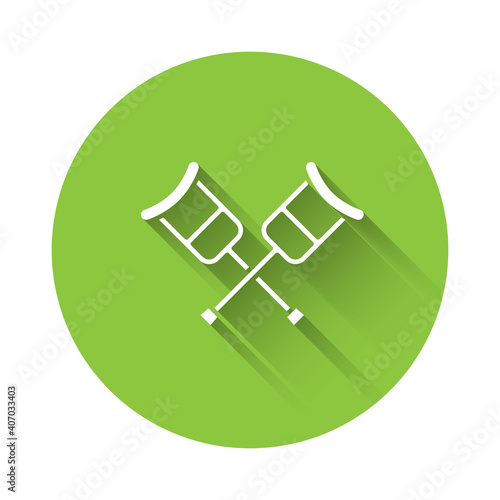 White Crutch or crutches icon isolated with long shadow. Equipment for rehabilitation of people with diseases of musculoskeletal system. Green circle button. Vector.