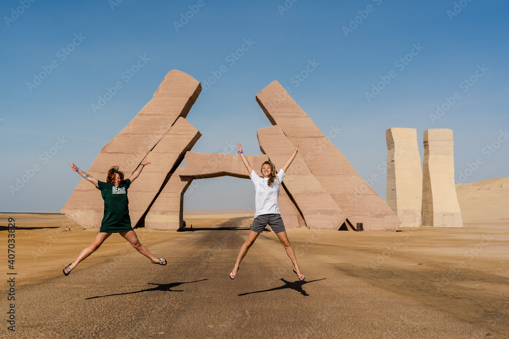 Fototapeta premium Girls jump near huge Gate of Allah, Ras Mohammed national park in Egypt. Desert