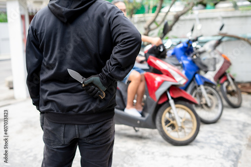 Fototapet Criminal with knife weapon hidden behind his back