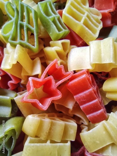 Closeup of colorful pasta in shape of star, tree and present, vertical, macro