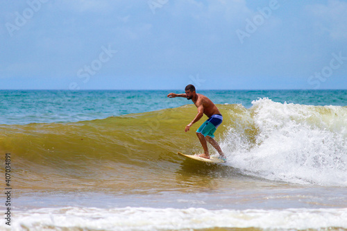 SURFISTA EM UMA PRAIA DE GUARAPARI - ES, BRASIL.