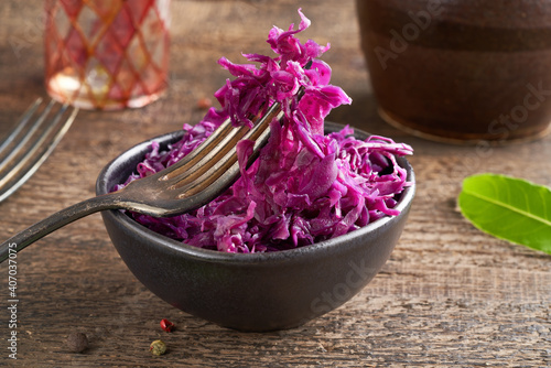 Red fermented cabbage on a fork in a bowl