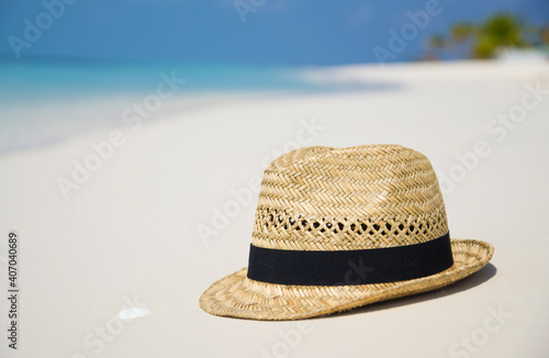 Straw hat on a paradise tropical beach with turquoise sea  Kuredu  Maldives. Concept of traveling  getaway  wanderlust and feeling free