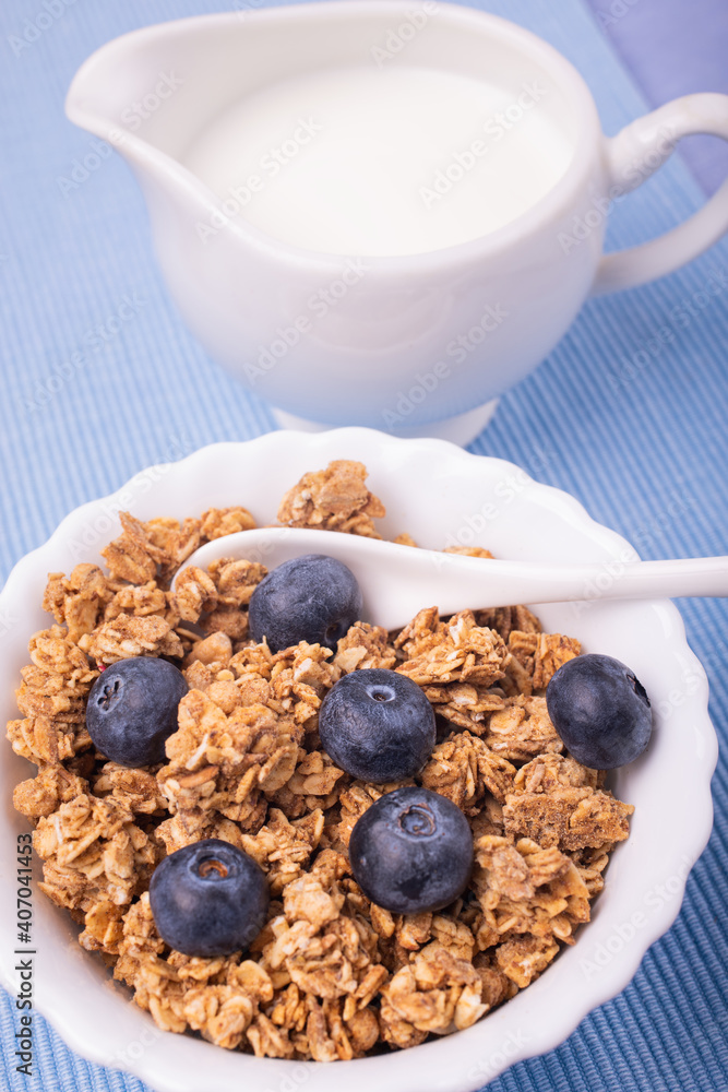 on lavender blue table, healthy breakfast with crunchy wholemeal muesli of barley and oats, blueberries and fresh milk. on lavender blue table, healthy breakfast with crunchy wholemeal muesli of barley and oats, blueberries and fresh milk.