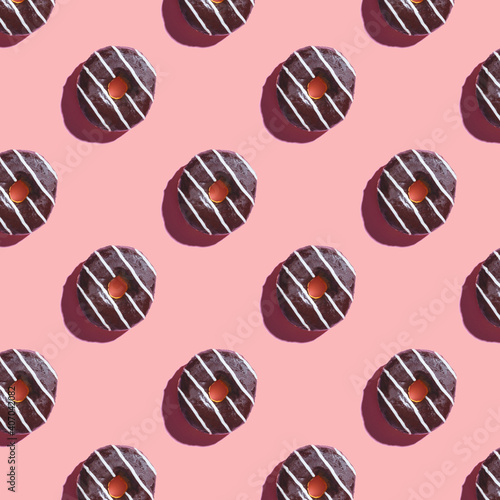 the pattern of a donut covered in chocolate with white stripes on a pink background