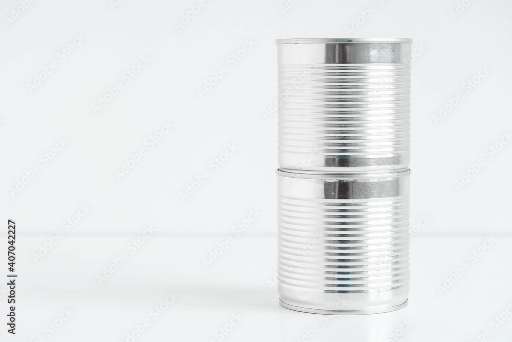 Two aluminum closed metal cans on a white table. Copy, empty space for text Two aluminum closed metal cans on a white table. Copy, empty space for text