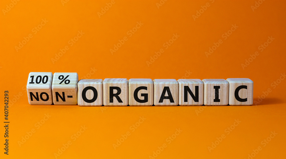100 percent organic symbol. Fliped wooden cubes and changed words non-organic to 100 percent organic. Beautiful orange background, copy space. Business, healthy lifestyle 100 percent organic concept. 100 percent organic symbol. Fliped wooden cubes and changed words non-organic to 100 percent organic. Beautiful orange background, copy space. Business, healthy lifestyle 100 percent organic concept.