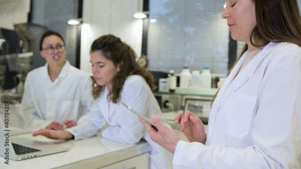 Group of scientists discussing research details in lab Group of scientists discussing research details in lab