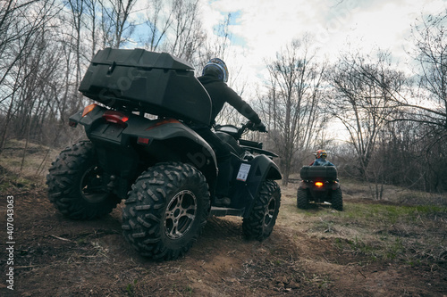 People ride quad bikes in the autumn forest, all-terrain vehicle