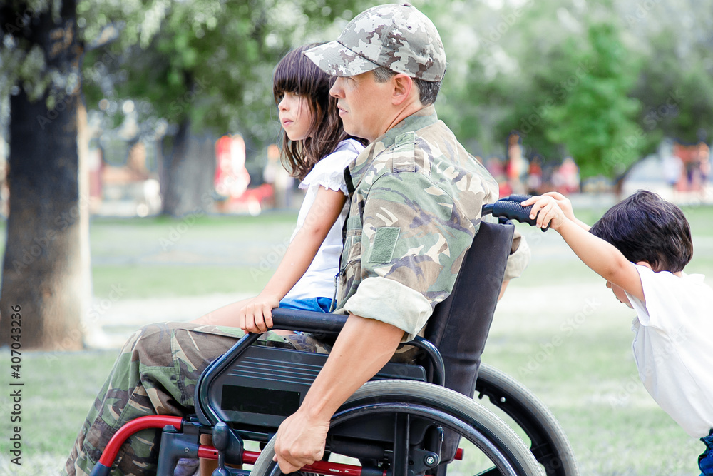Foto de Disabled military veteran walking with two children in park