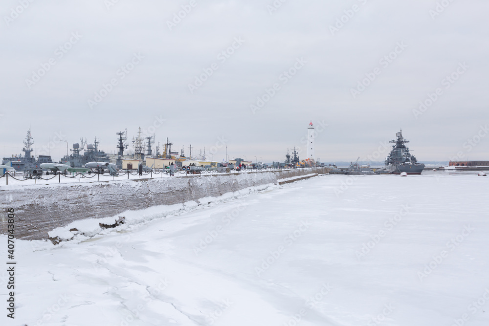 Picturesque panorama of dock with military ships and a lighthouse in Russia.