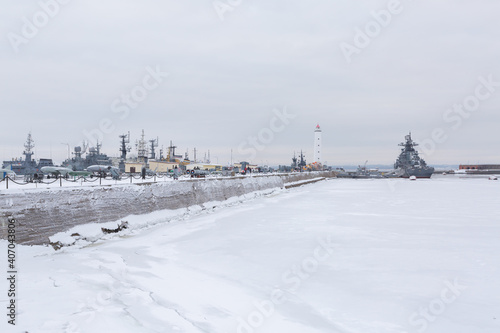 Picturesque panorama of dock with military ships and a lighthouse in Russia. © Daria