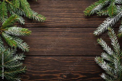 Christmas or New Year background with fir branches on the right and left side on dark wooden background. Place for your text.