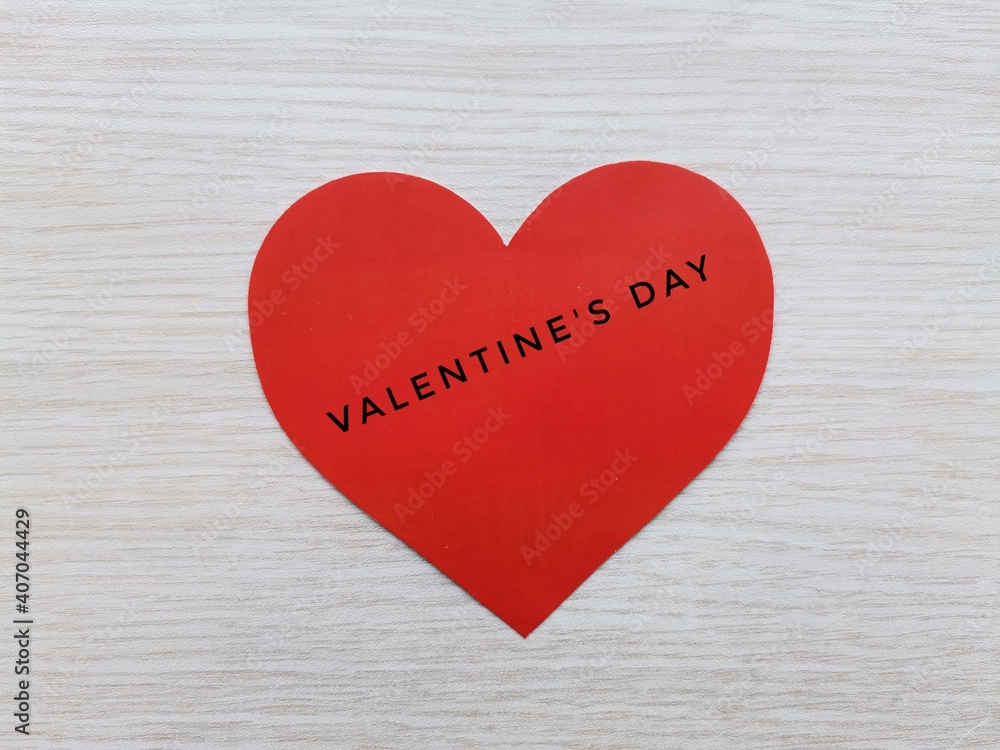 Red heart inscribed on Valentine's Day. Wooden background and red heart. Red heart inscribed on Valentine's Day. Wooden background and red heart.