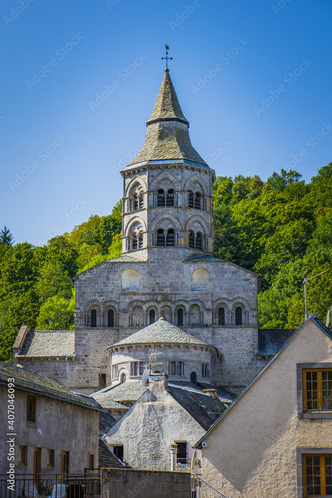 The romanesque basilica in the small medieval town of Orcival in Auvergne, France.  View of the apse and the chevettes