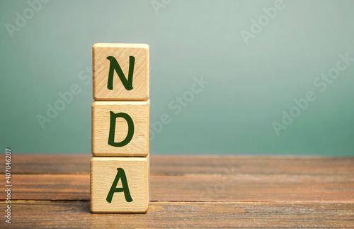 Wooden blocks with the word NDA - Non disclosure agreement. A legal contract entered into by two parties with limited access to third parties. Business concept photo