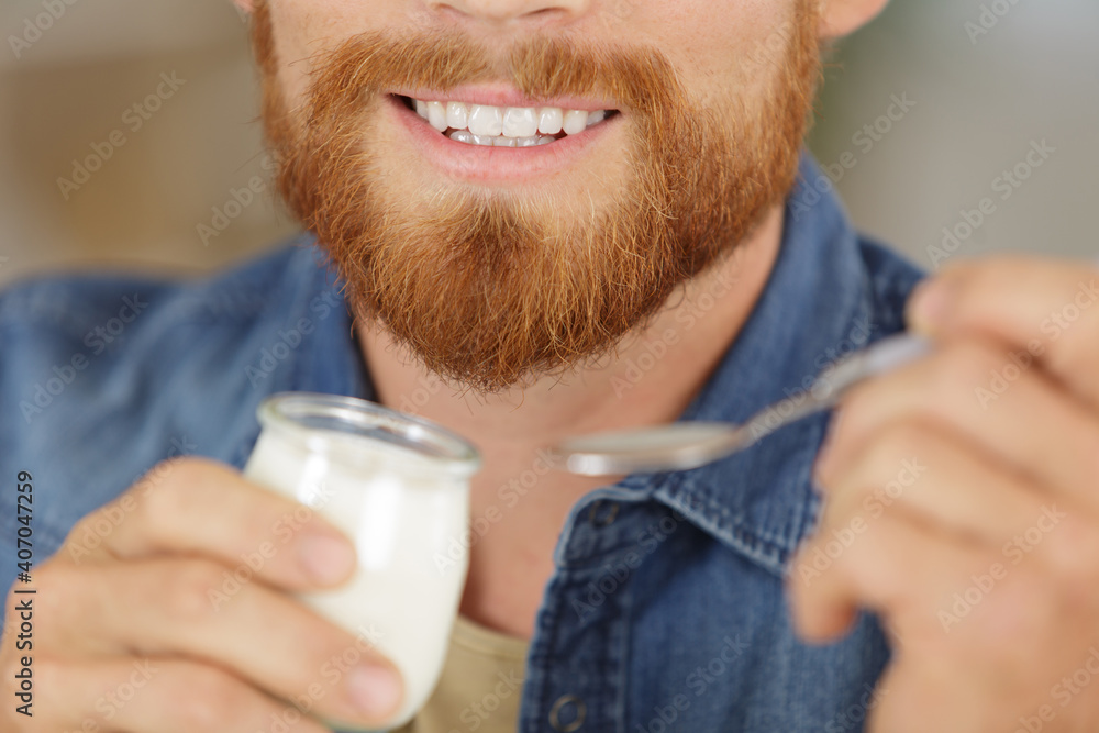 a young man eating yogurt a young man eating yogurt