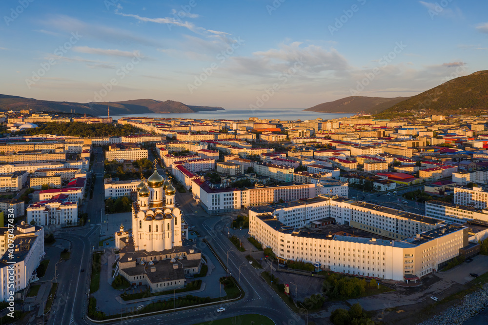 Aerial view of the city of Magadan. Beautiful morning cityscape. Top view of the Cathedral, streets and buildings illuminated by the sun at sunrise. Magadan, Magadan Region, Russian Far East. Russia.