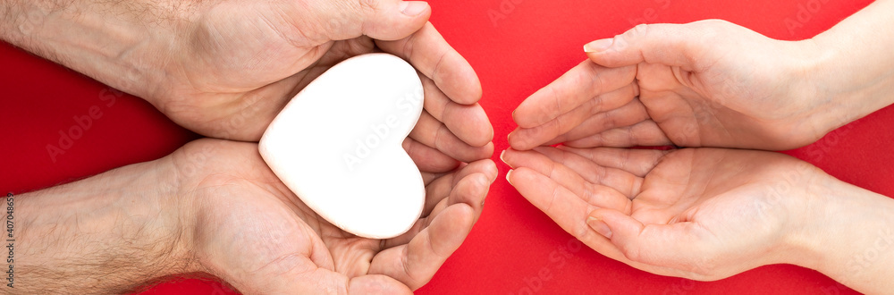 male and female hands with a white heart, health care, love and family insurance concept, world heart day, world health day, foster family, international family day male and female hands with a white heart, health care, love and family insurance concept, world heart day, world health day, foster family, international family day