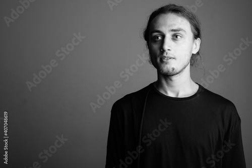 Young handsome man wearing black shirt against gray background