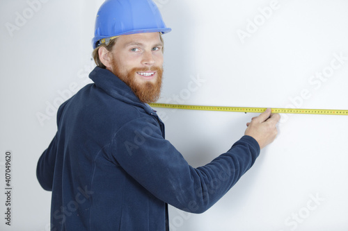 happy man measuring a wall using a ruler