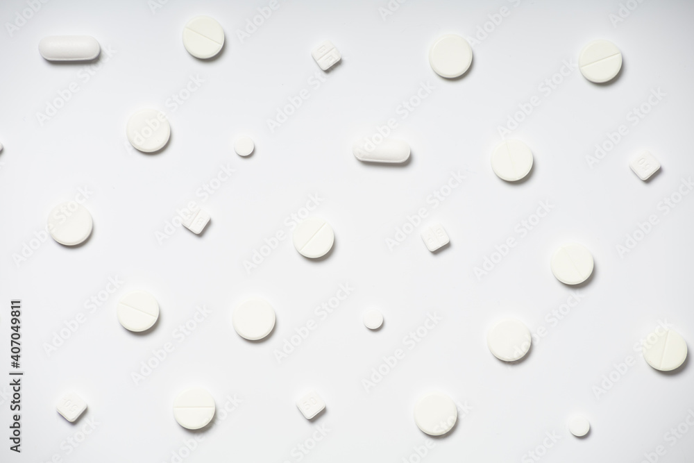 White pills on white background pattern
