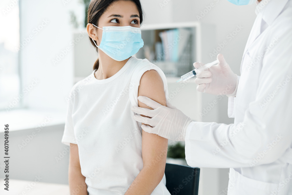 doctor in protective gloves holds a woman's hand and injects a vaccine against covid-19 coronavirus doctor in protective gloves holds a woman's hand and injects a vaccine against covid-19 coronavirus