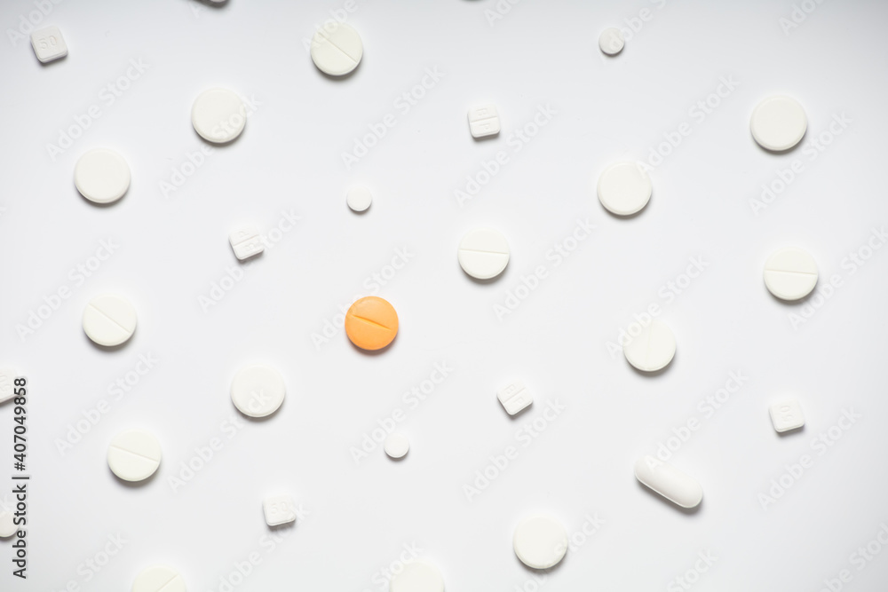 One colored pill on a background of white pills