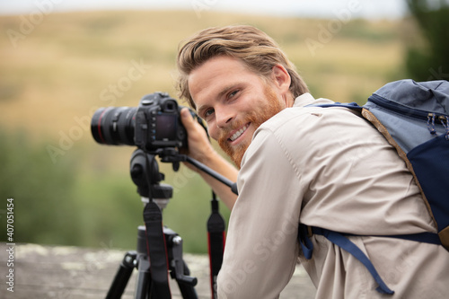 male photographer taking landscape pictures with tripod