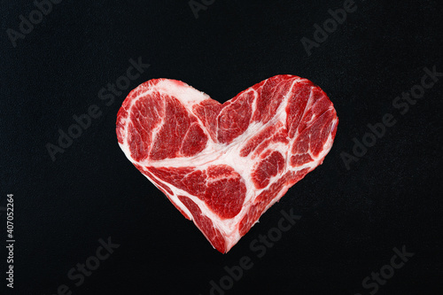 Fresh raw meat in the shape of heart on a black background