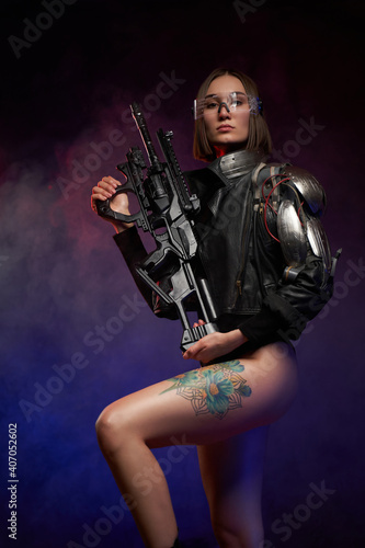 Female warrior in cyberpunk style poses in dark background. Seductive and slim woman with glasses and cybernetic hand dressed in black jacket.
