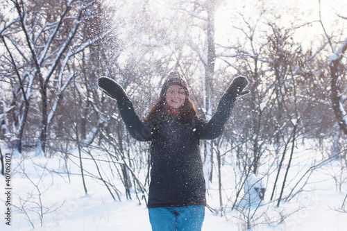Beautiful woman having fun in snowy forest.