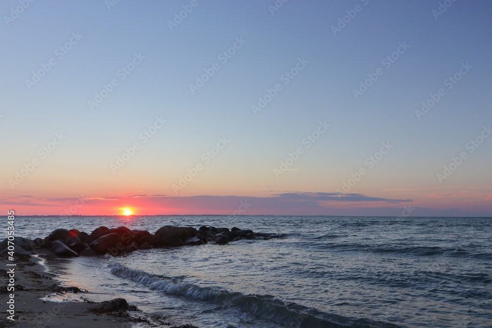 Rock groyne by the sea in beautiful coastal landsacpe at sunset.