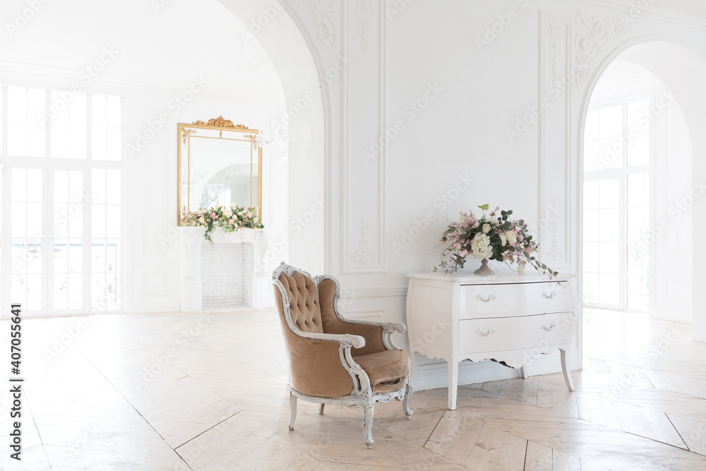 Fototapeta premium chic white huge spacious hall with a minimum of expensive antique furniture. Baroque interior design with ornament on the walls and parquet on the floor.