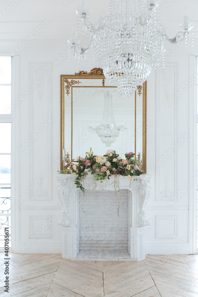 Fototapeta premium chic white huge spacious hall with a minimum of expensive antique furniture. Baroque interior design with ornament on the walls and parquet on the floor.
