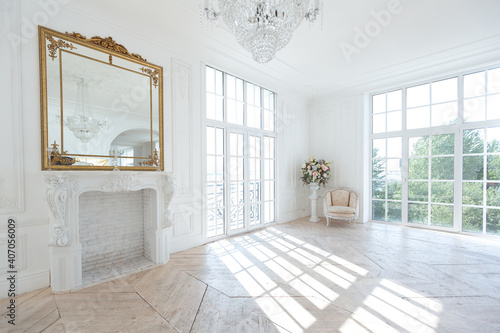Fototapeta Naklejka Na Ścianę i Meble -  chic white huge spacious hall with a minimum of expensive antique furniture. Baroque interior design with ornament on the walls and parquet on the floor.