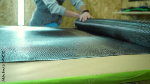 A roll of carbon fiber is spread on a table