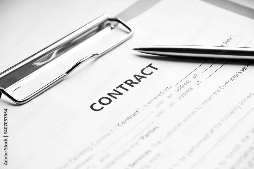 Close-up of a silver pen on docunent contract. Legal contract signing, buy sell real estate contract agreement sign on document paper with black pen Close-up of a silver pen on docunent contract. Legal contract signing, buy sell real estate contract agreement sign on document paper with black pen