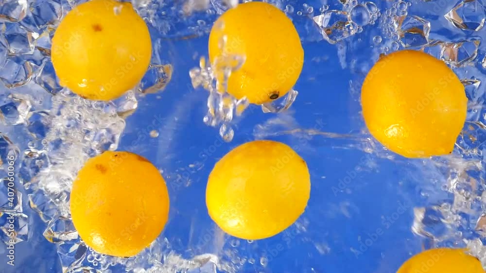 Lemons on a blue background are slowly doused with ice water. Lemons on a blue background are slowly doused with ice water.