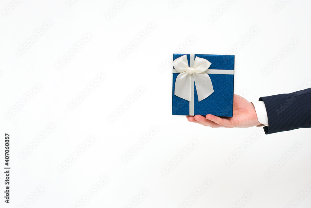 Unrecognizable businessman wearing suit, offering blue gift box with bow ribbon isolated on white background.Copy space Unrecognizable businessman wearing suit, offering blue gift box with bow ribbon isolated on white background.Copy space