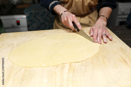 Woman cutting dough into strips for cooking chak-chak