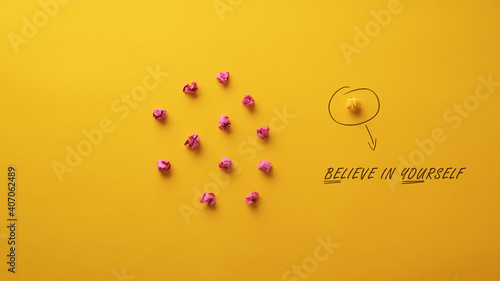 Believe in yourself message spelled on yellow background photo